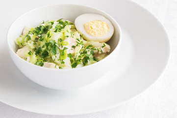 chicken breast and white cabbage salad dressed with mayonnaise and decorated with egg and parsley
