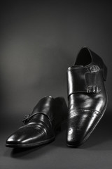 Close up of beautiful black leather men's shoes. Fashionable shoes isolated on black background.