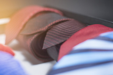 Close up of men's neckties. Modern ties for men isolated on a black background. Lens flare in the background.