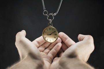 Close up of an old gold pocket watch. Beautiful antique watch. Man's hand holding a pocket watch.