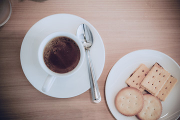 Hot coffee for service customer on wood table vintage style,dark tone,film,pastel,selective focus,cracker