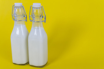 Two milk bottle on yellow background
