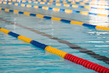 The view of an empty public swimming pool indoors. Lanes of a competition swimming pool. Sport concept