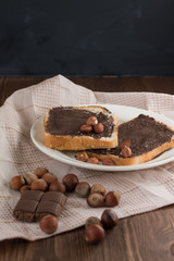 toast with peanut butter on a plate on the table with hazelnuts