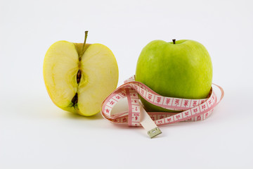 Fresh green apples with measuring tape concept of weight loss Isolated on a white background.