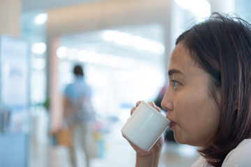 Asian woman drink coffee Waiting to get service center car,dark tone