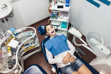 The girl patient with a retractor at the dentist office