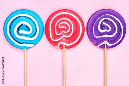 “Lollipops in blue, pink and purple colors against a soft pink wood