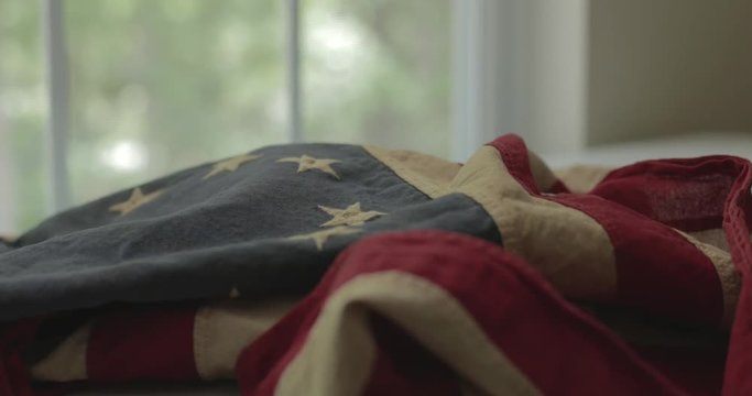 American flag detail with red and white stripes with field of blue and circle of 13 stars, the flag designed by Betsy Ross during the American Revolution. Shot in cinematic 4K.
