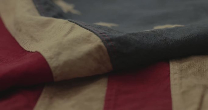 American flag detail with red and white stripes with field of blue and circle of 13 stars, the flag designed by Betsy Ross during the American Revolution. Shot in cinematic 4K.