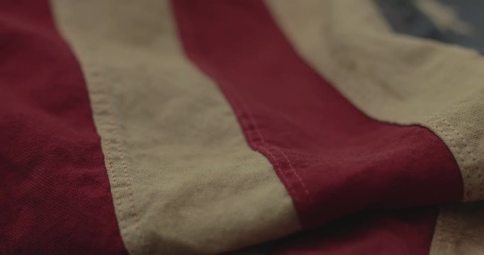 American flag detail with red and white stripes with field of blue and circle of 13 stars, the flag designed by Betsy Ross during the American Revolution. Shot in cinematic 4K.