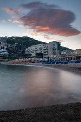 Naklejka na ściany i meble Hotel resort on the beach with blurred water surface at sunset, Budva, Montenegro