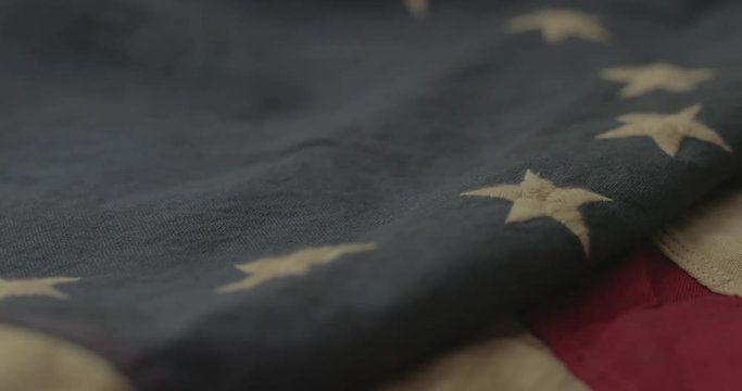 American flag detail with red and white stripes with field of blue and circle of 13 stars, the flag designed by Betsy Ross during the American Revolution. Shot in cinematic 4K.