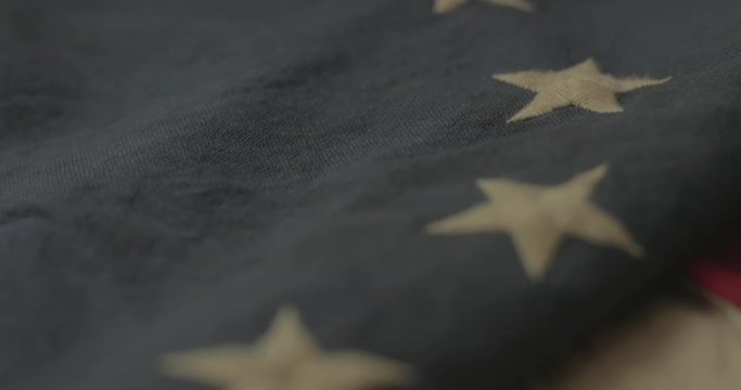 American flag detail with red and white stripes with field of blue and circle of 13 stars, the flag designed by Betsy Ross during the American Revolution. Shot in cinematic 4K.