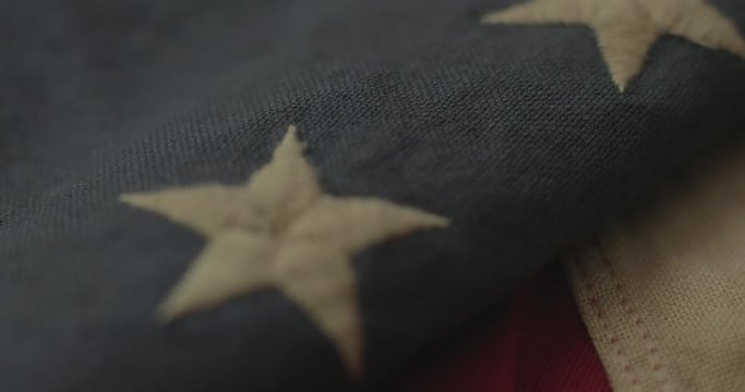 American flag detail with red and white stripes with field of blue and circle of 13 stars, the flag designed by Betsy Ross during the American Revolution. Shot in cinematic 4K.