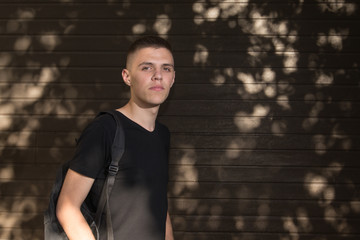 Teenage Boy looking at camera on background of Urban wall