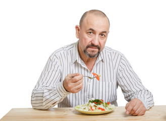 Man eating the salad with a raw vegetables