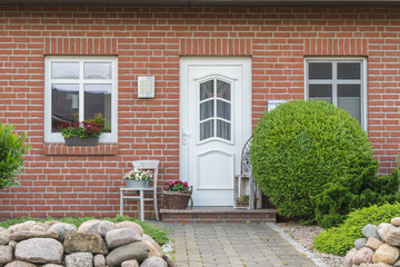 Weiße Tür eines Hauses mit weißen Fenstern