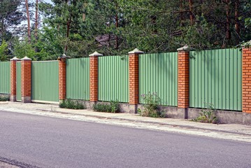 зелёно коричневый забор и ворота перед...