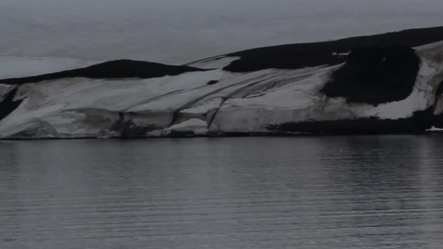 Franz-Joseph Land. Rocks, Islands, snowfields, glacier, in strait floats small ic
