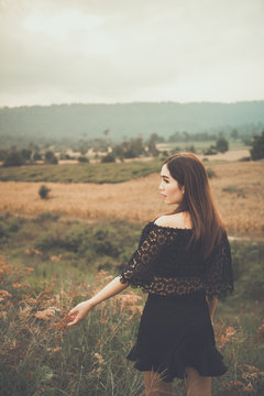 Beautiful thai woman use hand touch flower grass,very sad from unrequited love,rethink,think over,vintage style,dark tone,broken heart,asian girl