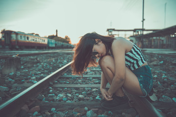 Hipster girl feeling sad  at the rail way in the evening japanese tone,vintage style,dark ton,film,pastel
