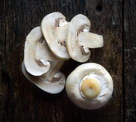Fresh white mushrooms champignon on wooden background