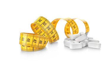 Weight loss supplements and measuring tape isolated on white