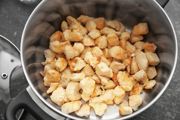 Pot with turkey fillet on table, closeup