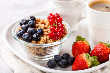 Breakfast - muesli, berries and coffee. Selective focus. Copy space