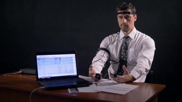 A man connected to polygraph trying to avoid answering. 4K 60 fps.