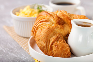 Breakfast - croissant, egg and coffee. Selective focus.