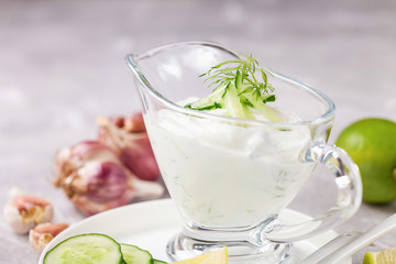 Tzatziki sauce in a glass sauce-boat. Ingredients for a dzadziki. Turkish dish cacik. Selective focus. Copy space