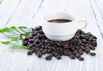 Roasted coffee beans  cup of coffee and leaves isolated on a white background