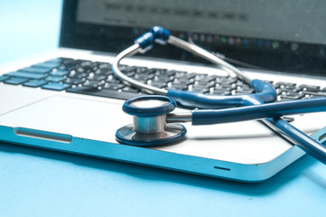 stethoscope, laptop on blue color background. Medical technology concept.