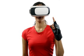 Young attractive woman wearing virtual reality goggles and remote control glove