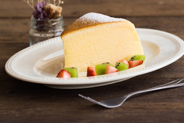 Homemade Japanese cheesecake so delicious, fluffy,lite and soft,sparkling with icing, fresh fruit:kiwi and strawberry.Soft cheesecake Japanese style.Souffle cotton cheese cake.Vintage tone style.