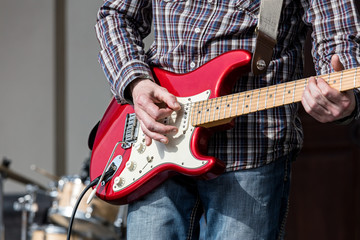 man performing on electrical guitar in the street during concert closeup