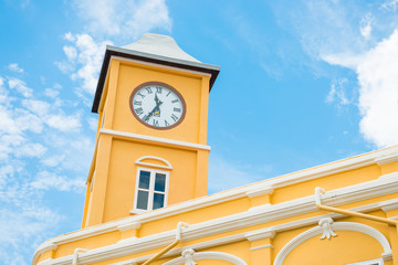 building with clock tower in Sino-Portuguese style against blue sky in Phuket old town