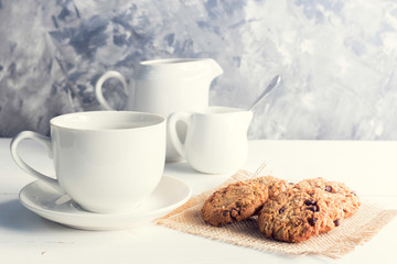 cup of coffee,milk,sugar,chocolate chip cookies  on white wooden background with loft wall style with light in concept relax time