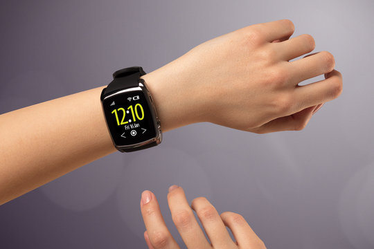 Female hand wearing and pressing smartwatch