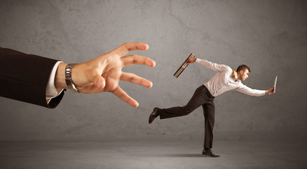 Businessman running from hand
