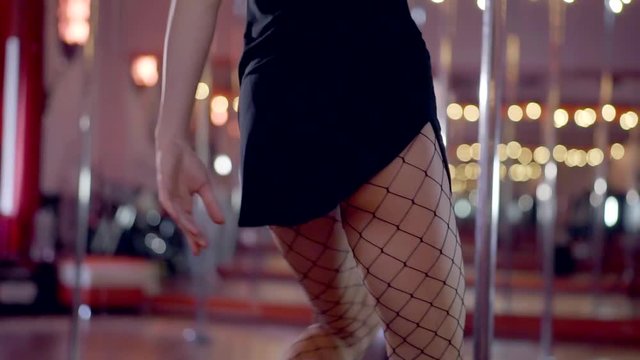 Slender sexy ass and legs in stockings dancing on stage in a nightclub pole.