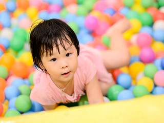 Fototapeta na wymiar Happy Asian child with colorful plastic balls toy