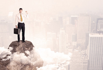 Happy businessman standing on stone top