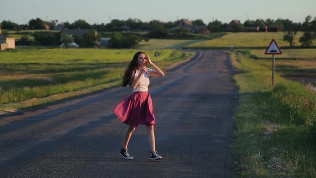 Brunette girl dancing on a road
