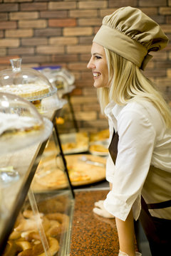 Young woman selling bread in baker shop