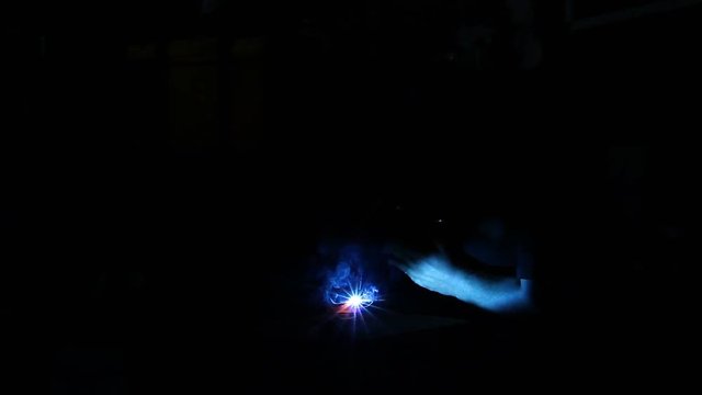 Arc welder with welding sparks.
Flashes and lot of sparks from welding work at dark in workshop.
