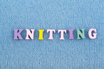Knitting. Blue Knitted Fabric Texture. Word composed from ABC alphabet letters.