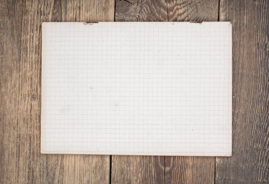 Notebook paper on wood background.Top view. 